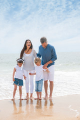 Portrait of a happy family standing on the beach