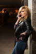 © Wrangler - Young fashion blond woman in leather jacket calling on mobile ph