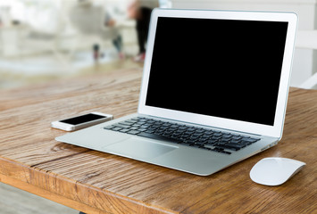 laptop with smart phone on wood table