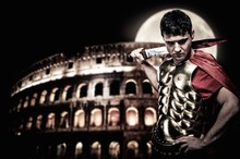 Roman Legionary Soldier In Front Of Coliseum At Night Time