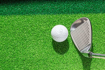 Wall Mural - Golf club and golf ball on green grass background.