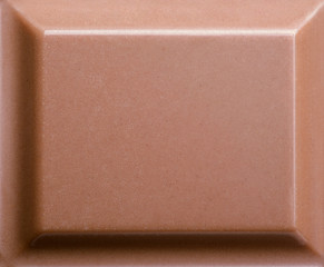 Top view of milk chocolate piece. Closeup photo