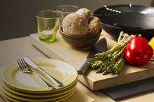 Bread, Veggies, Knife, Glass And Plates On Table