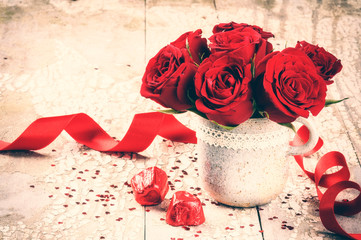 Valentine's setting with bouquet of red roses and chocolate