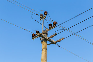 Old wooden power transmission pole with wires