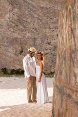 Wall Mural - young couple in a beach with shipwreck