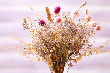 Canvas Print - Bouquet of dried flowers in vase on color planks background