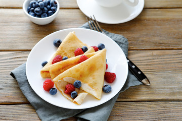 Wall Mural - summer crepes with berries on white plates