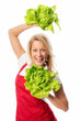 Frau mit Schürze hält Salatköpfe