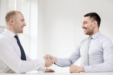 Sticker - two smiling businessmen shaking hands in office