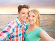 © Syda Productions - smiling couple with smartphone on summer beach