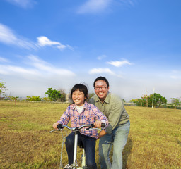 Wall Mural - happy Father teaching his daughter to ride bicycle