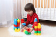© ivolodina - Lovely 2 years toddler playing plastic blocks