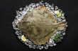 Fresh turbot fish on ice on a black stone table top view
