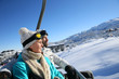 © goodluz - Couple sitting on ski resort chairlift