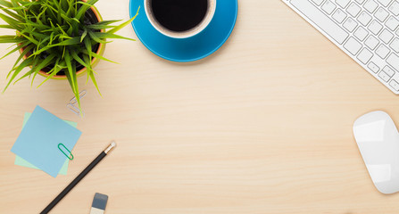 Office table with coffee cup, computer and flower