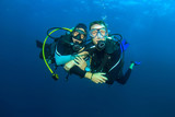 Fototapeta Do akwarium - Happy couple scuba diving together