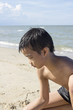© Suphatthra China - Asian Thai boy playing sand