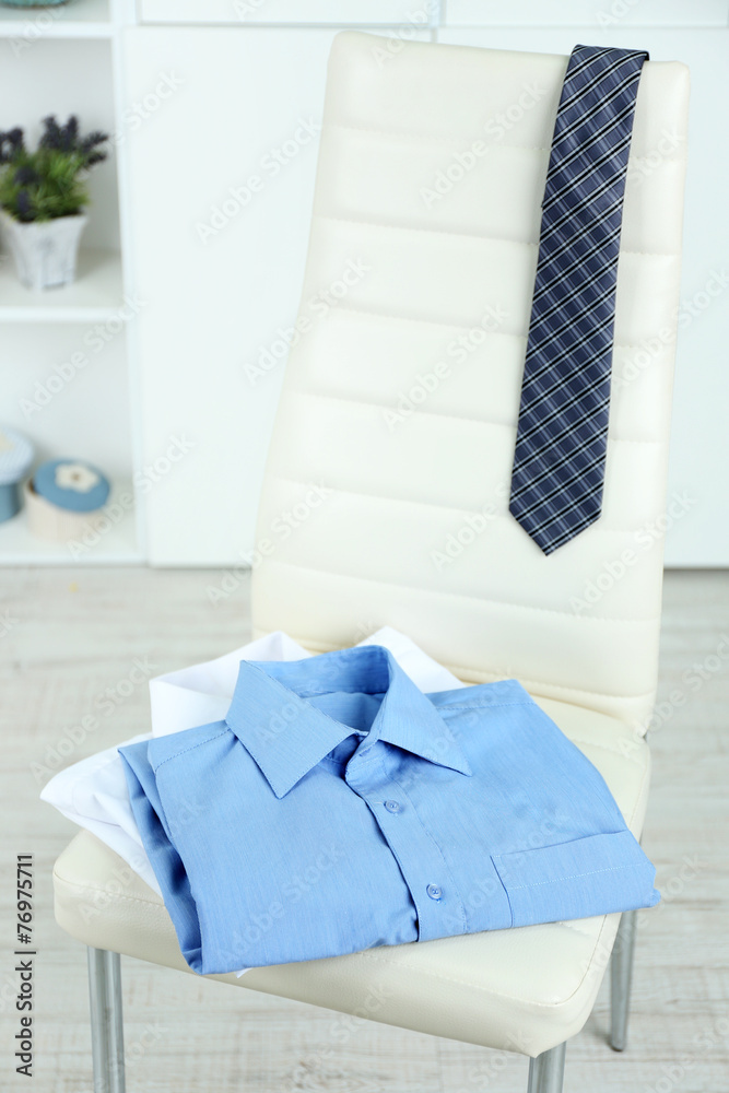 Men's clothes on chair with shelf on background