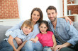 © goodluz - Cheerful family at home sitting in sofa