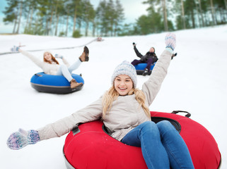 Sticker - group of happy friends sliding down on snow tubes