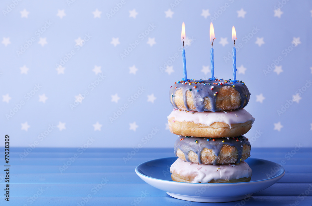 Delicious donuts with icing and birthday candles