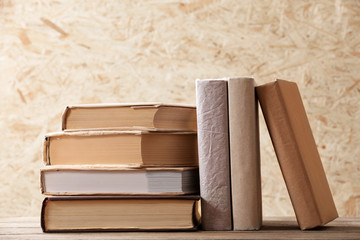 Poster - Stack of books on wooden hardboard background