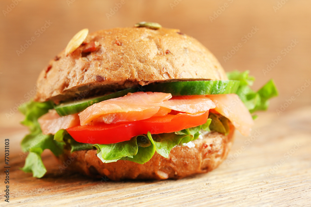 Sandwich with salmon on wooden background