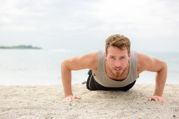 Wall Mural - Push-up crossfit man fitness training on beach