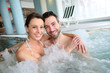 © goodluz - Couple enjoying bath in spa center jacuzzi