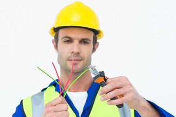 Poster - Handsome electrician cutting wire with pliers