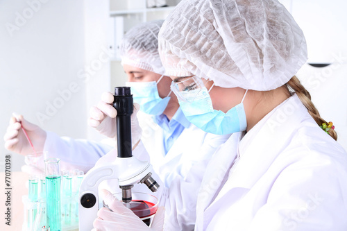Fotografía Male and female scientists using microscope in laboratory