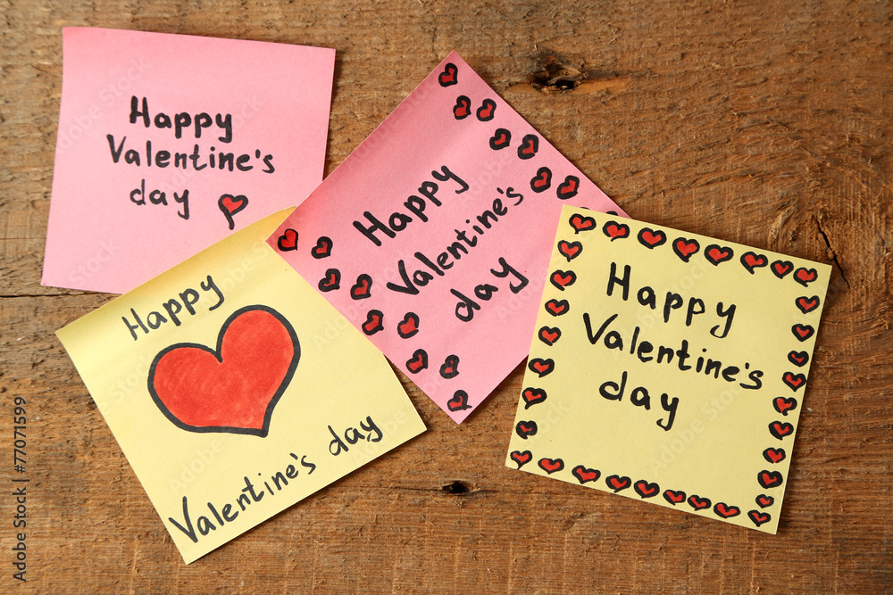 Valentines day notes on wooden background