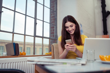 Wall Mural - frau mit handy und laptop in ihrer wohnung