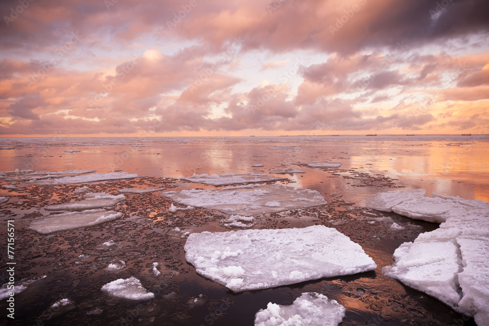 Winter coastal landscape with melting ice fragments