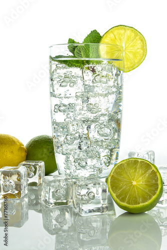 Fototapeta na wymiar Glass o sparkling water with ice cubes on white background