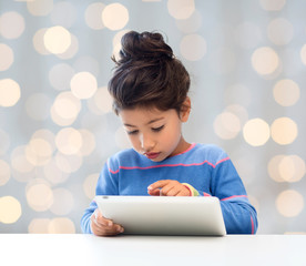 Poster - little girl with tablet pc over lights background