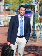 Wall Mural - smiling successful business man walking outside down the street