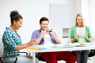 Wall Mural - students looking into devices at school