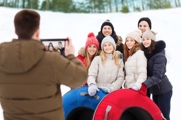 Wall Mural - group of smiling friends with snow tubes