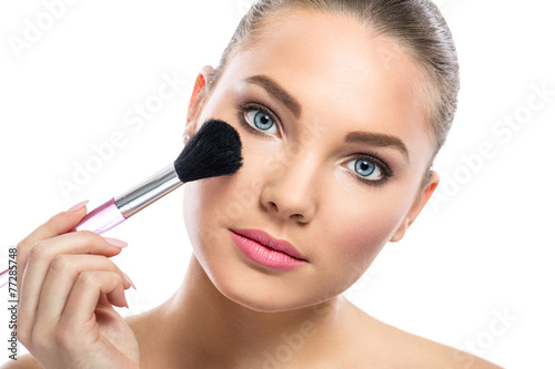 Fotografie, Obraz young woman with mirror applying powder on cheek