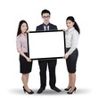 © Creativa Images - Multi ethnic teamwork holding whiteboard