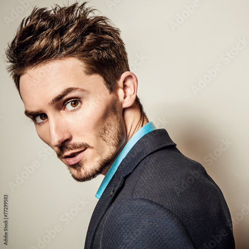 Naklejka na meble Elegant young handsome man in costume. Studio fashion portrait.