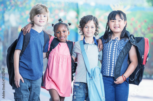 Happy multi race classroom embracing in the schoolyard Tablou Canvas