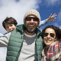 Wall Mural - Padres con hijo sonriendo con cielo de fondo