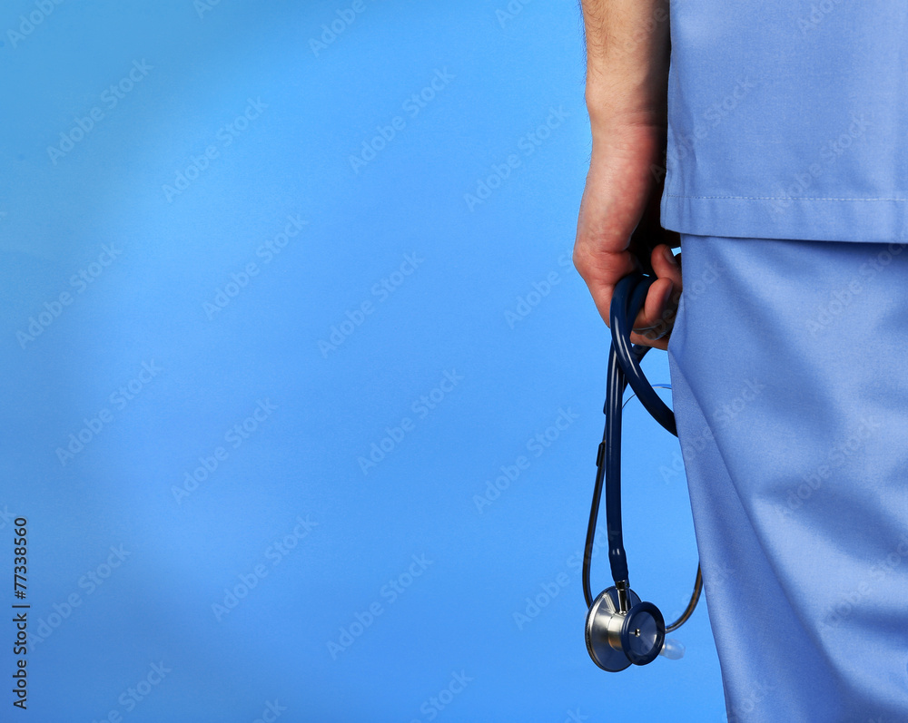 Male doctor with stethoscope on blue background