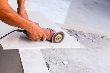 Labor cutting tile floor for new house building