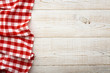 © missty - Top view of checkered tablecloth on white wooden table.