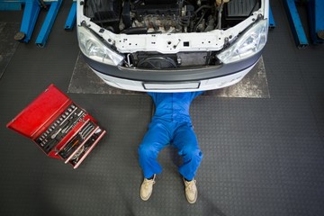 Poster - Mechanic lying and working under car