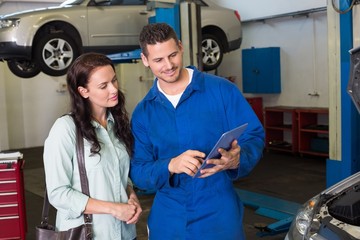 Wall Mural - Mechanic showing tablet pc to customer